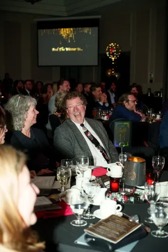 The audience laughing as Cliff emcees an event