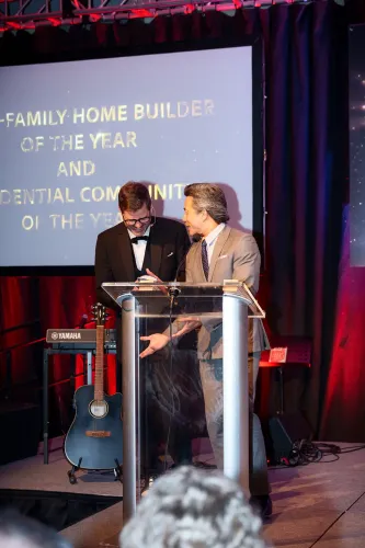 Cliff on stage as emcee with another individual at the podium