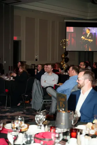 An audience looks on as Cliff sings on stage with his guitar