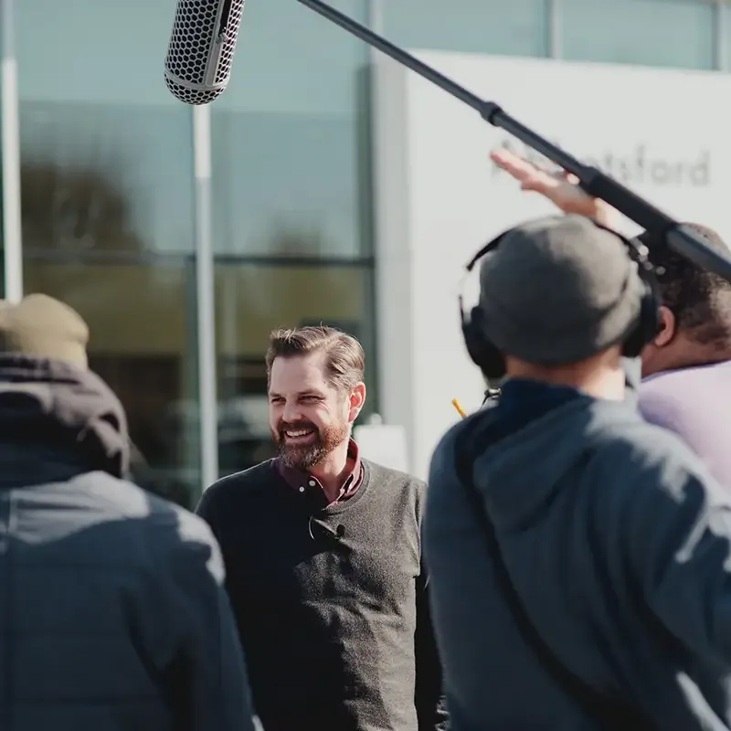 Cliff on set with the crew including a sound guy holding the boom mic