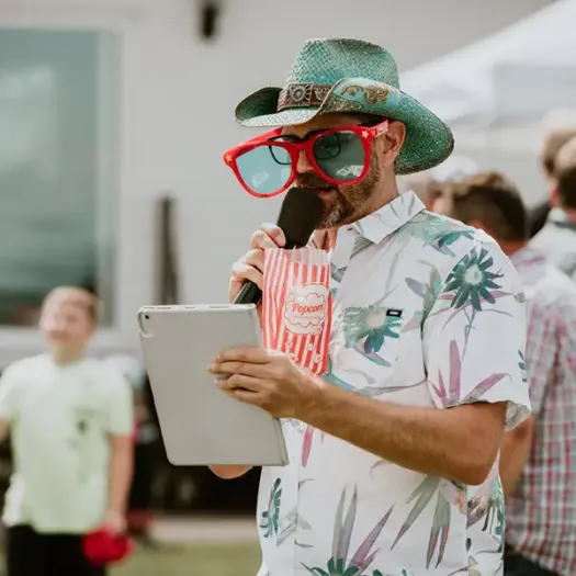 Cliff in a cowboy hat with clown glasses as he emcee's an event