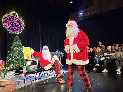 Tia and Cliff as Santa's on stage at a Very Very Improv show
